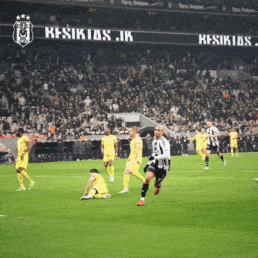 a soccer game is being played in front of a large sign that says beşiktaş
