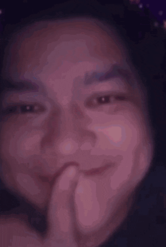 a close up of a person 's face with a hand on their chin