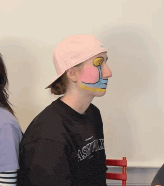 a person wearing a pink hat and a black sweatshirt with ashville on it