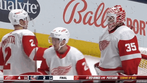 a hockey player with the number 35 on his jersey talks to another player