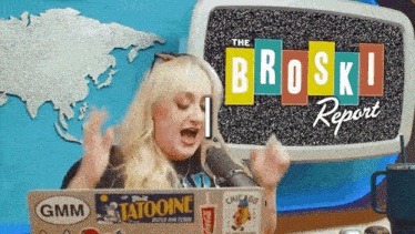 a woman sitting in front of a microphone with the broski report on the screen behind her