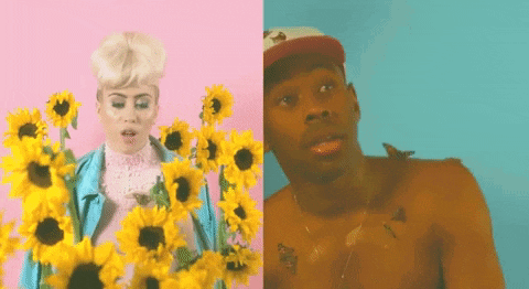 a woman and a man are standing next to each other holding sunflowers .