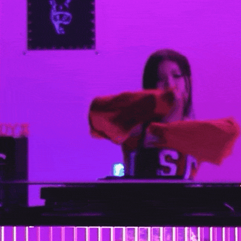 a woman wearing a red sweatshirt with the letters usc on it is standing in front of a purple wall .