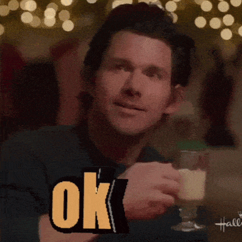 a man holding a glass of wine with the word ok on it