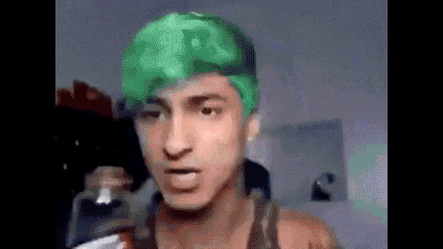 a man with green hair is making a funny face .