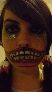 a close up of a woman 's face with a large smile painted on it