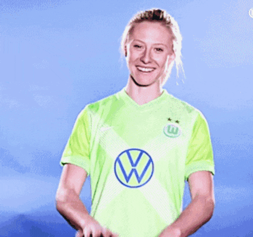 a woman wearing a green shirt with a blue w on it