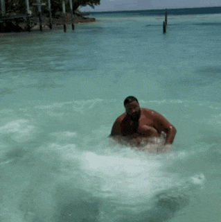a man with a beard is swimming in a body of water