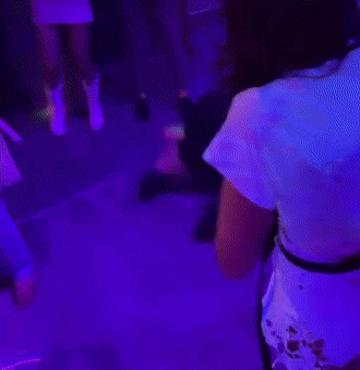 a person is laying on the floor in a dark room with purple and green lights