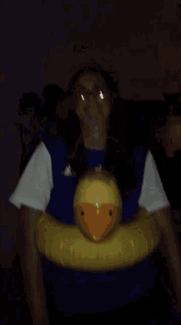 a woman in a blue shirt holds a yellow rubber duck