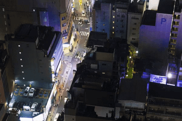 an aerial view of a city at night with a building that says p