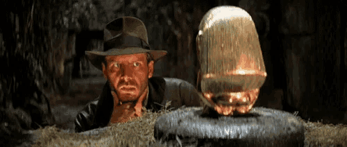 a man wearing a hat is looking at a glowing object