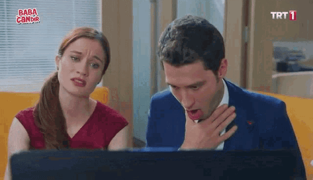 a man and a woman are looking at a laptop screen with baba camdir written on the bottom