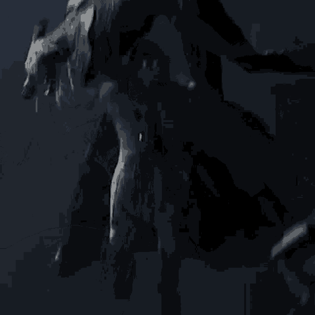a woman is being attacked by a monster in a dark room in a video game .