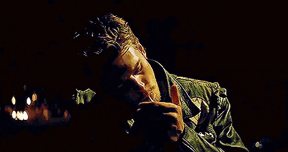 a man is lighting a cigarette with a lighter in his mouth .