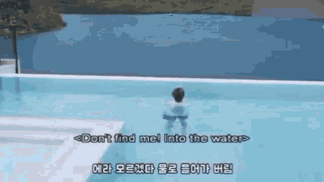 a man is swimming in a swimming pool with the words `` don 't find me into the water '' written on the bottom .