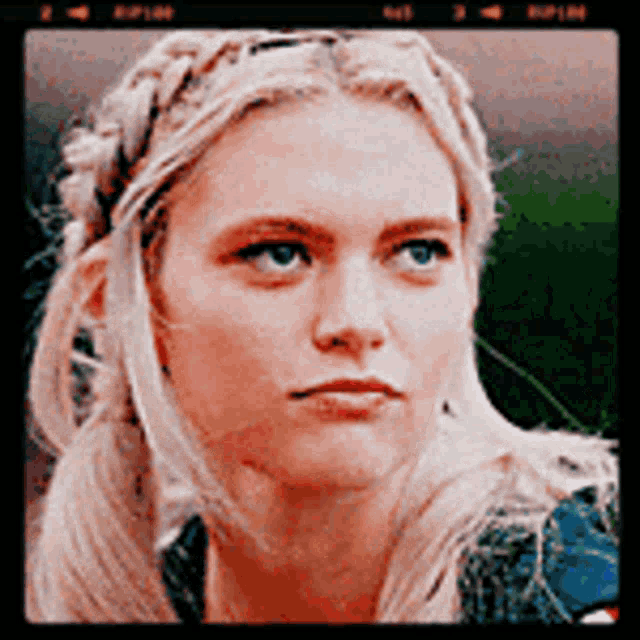 a close up of a woman 's face with braids on her hair