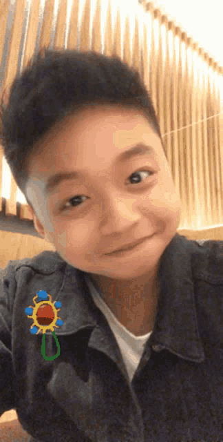a young boy wearing a jacket with a sunflower pin on it
