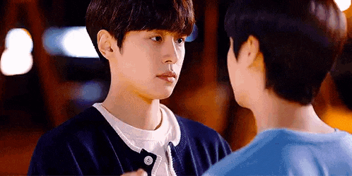 two young men are standing next to each other and looking at each other with their eyes closed .
