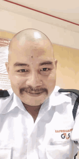 a bald man with a mustache is wearing a safeguard gs uniform