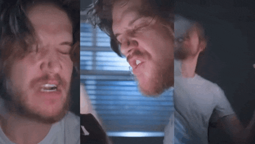 a man with a beard is making a funny face while looking at his phone