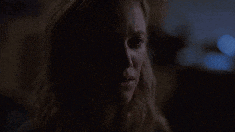 a close up of a woman 's face in the dark with a tear running down her cheek .