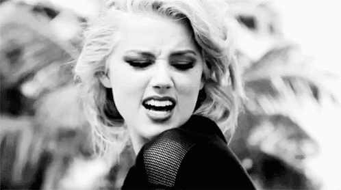 a black and white photo of a woman making an angry face .