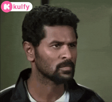 a man with a beard is wearing a black jacket and looking at the camera .