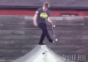a man is doing a trick on a skateboard while wearing a t-shirt that says superman