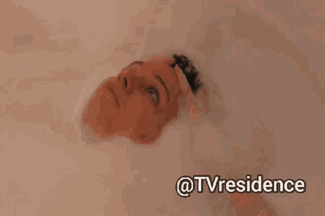 a woman is taking a bath with foam on her head and the words @tvresidence above her