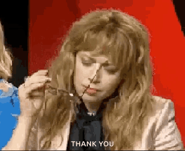 a woman is holding a pair of scissors in her mouth and says `` thank you '' .