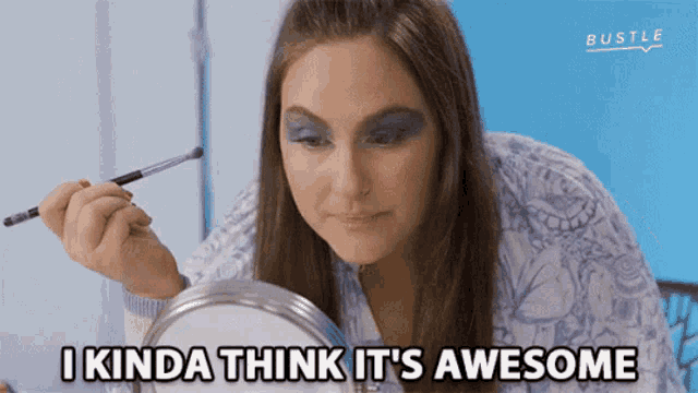 a woman is applying makeup in front of a mirror and says i kinda think it 's awesome