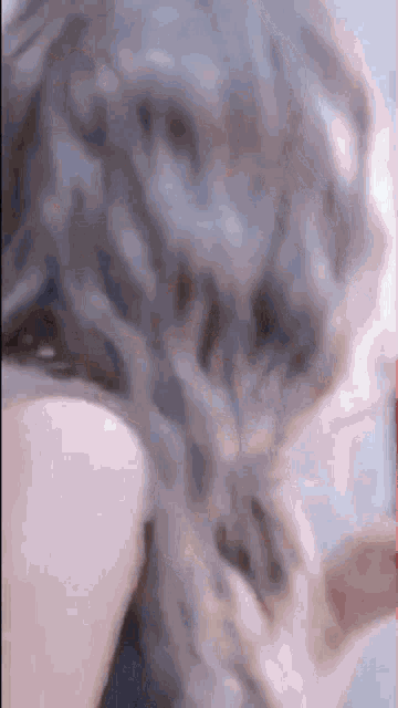 a close up of a woman 's hair being braided in a ponytail .