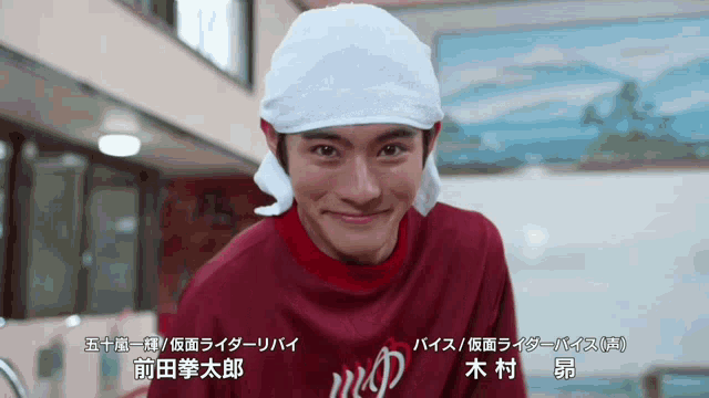 a man wearing a red shirt and a towel around his head