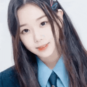 a close up of a young girl wearing a blue shirt and tie .