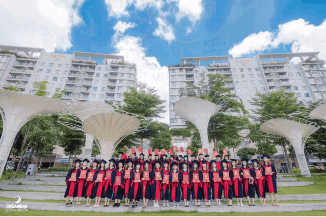 a group of graduates are posing for a picture in front of a building that says dreamers on it