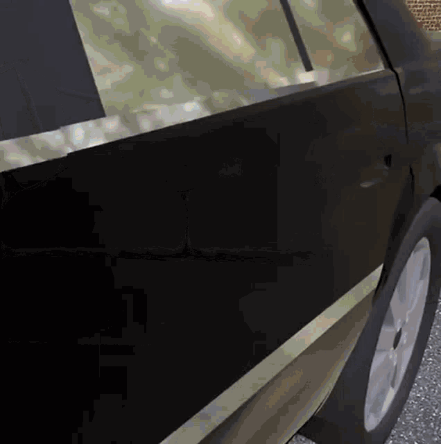 a close up of a car door with a brick wall in the background