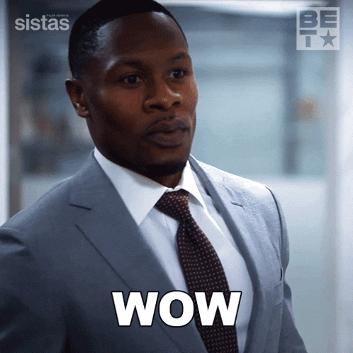 a man in a suit and tie with the word wow on his chest