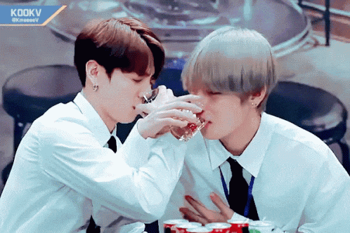 two men drinking from glasses with a sign that says kookv in the corner