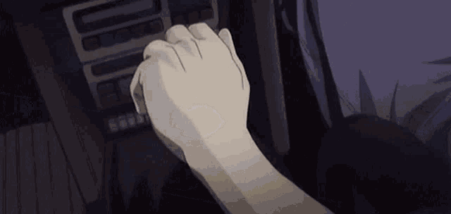 a person 's hand is pressing a button on a dashboard .