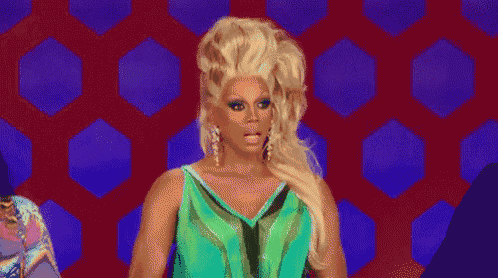 a drag queen in a green dress is making a funny face .