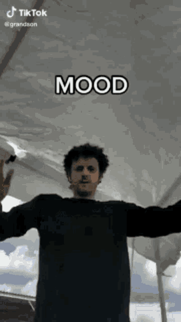 a man is standing under a tent with his arms outstretched and a caption that says mood