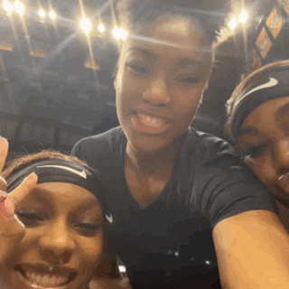 three women wearing nike headbands pose for a photo