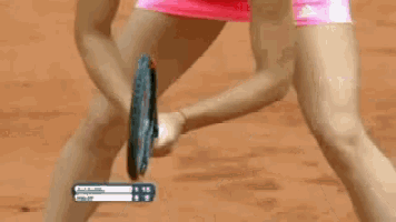 a woman in a pink dress is holding a tennis racquet in front of a scoreboard that says 1:15 on it