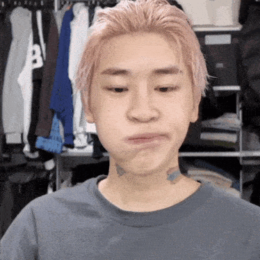 a young man with pink hair has a tattoo on his neck