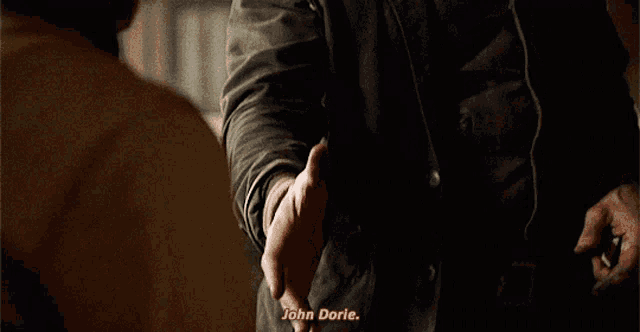 a man shakes another man 's hand and says " john dorle " at the bottom