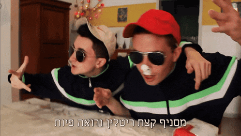 two men wearing sunglasses and a red hat with hebrew writing on the bottom
