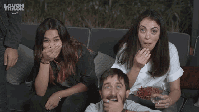 a group of people sitting on a couch with laugh track written on the bottom left