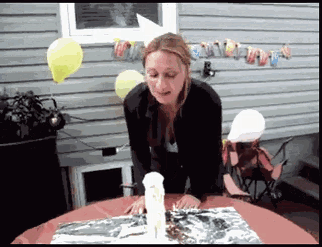 a woman is blowing out a birthday candle