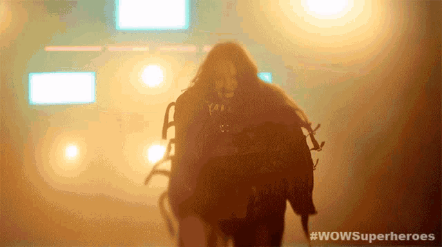 a silhouette of a woman in a dark room with the words wowsuperheroes below her